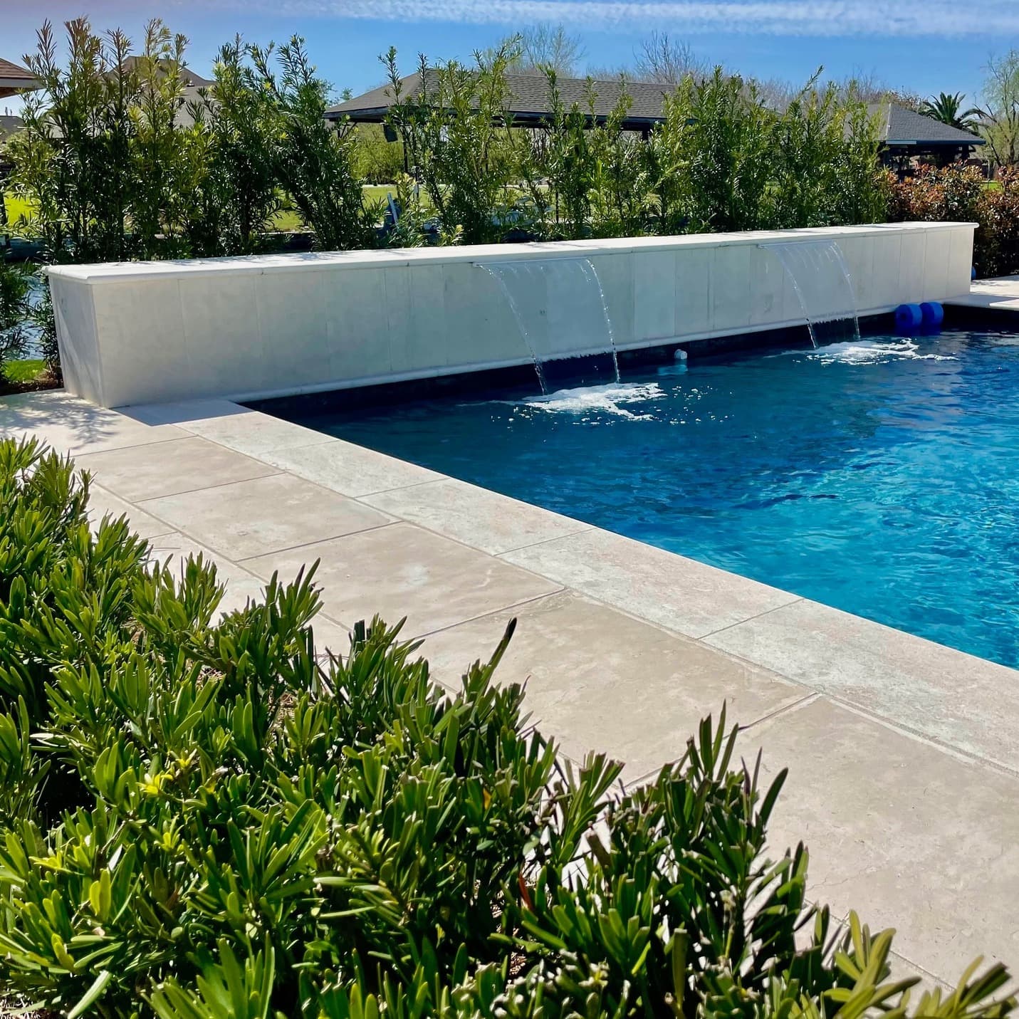 Pool with modern spillover water wall feature